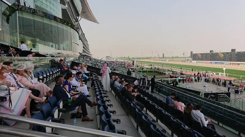A crowd in the grandstand at Meydan Racecourse during the Dubai World Cup meeting