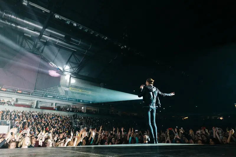 Imagine Dragons' singer on a long stage runway in front of a packed arena